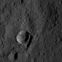 Oxo Crater, found to contain water ice. The streaky insides of this tiny crater look quite similar to the sides of Ahuna mons.